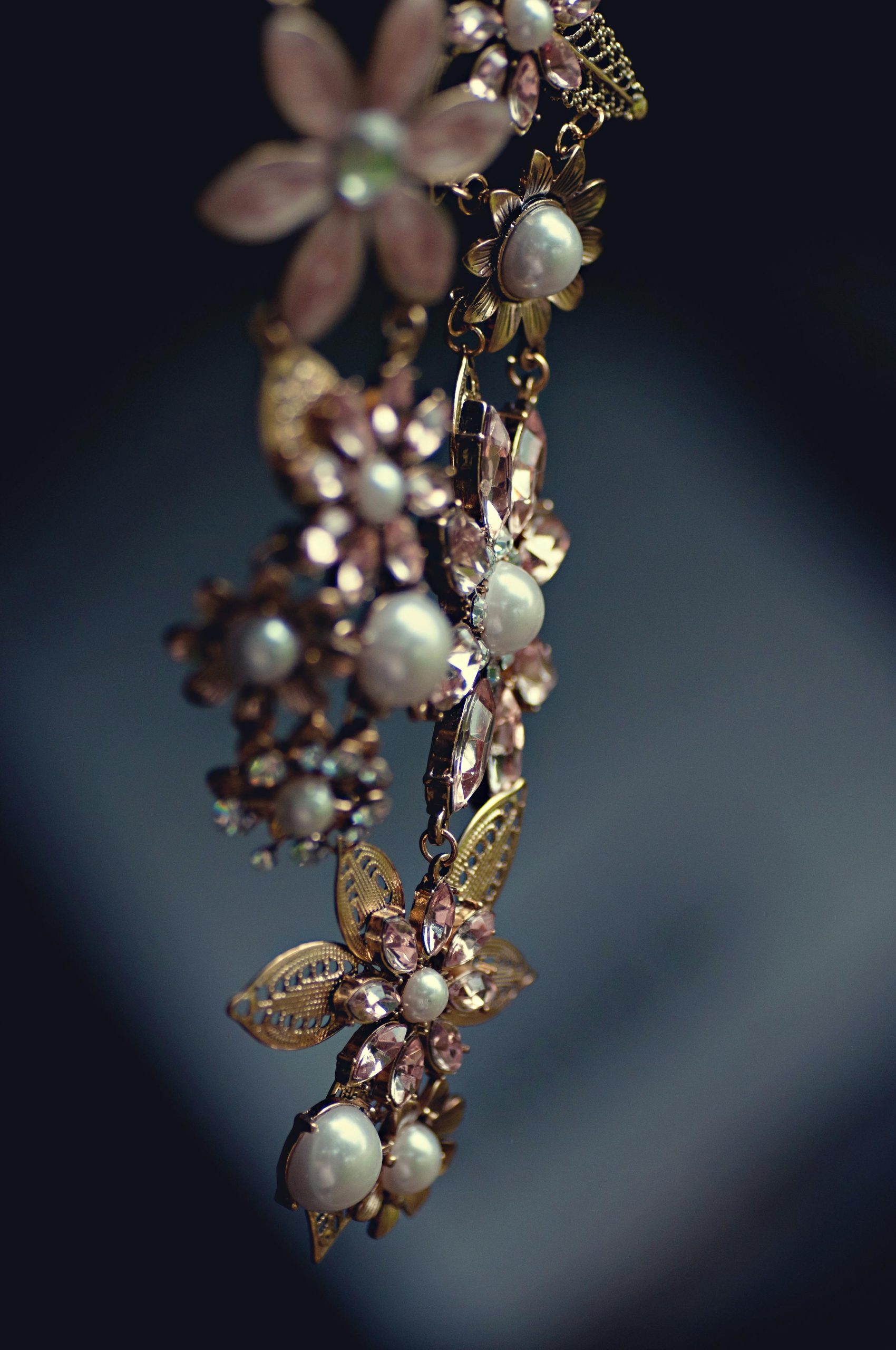 Close-up of a luxurious floral necklace featuring pearls and gemstones with a vintage charm.